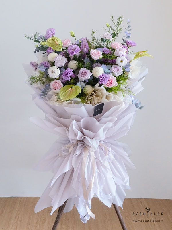 Moonlight Sonata Opening Flower Stand Fresh flower stand with Lilac eustoma, lilac rose, pink rose, white ping pong, gradient green anthurium, plenty of eucalyptus and fish tail fern asparagus